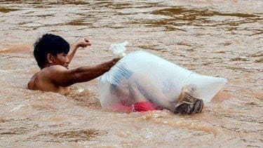 Seorang pria rela seberangi sungai berlumpur dan lindungi anak-anak agar bisa sekolah (Sumber: World of Buzz)
