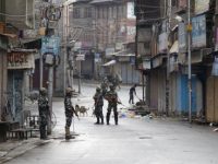 Tentara paramiliter India berjaga di jalanan yang sepi saat jam malam di Srinagar, Kashmir yang dikuasai India