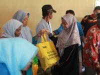 Penyerahan bingkisan oleh Direktur KNPI Care, Safira Syamsari kepada masyarakat prasejahtera.