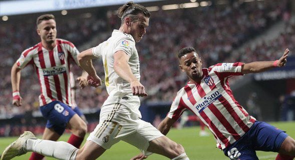 Bek Atletico Madrid, Renan Lodi mencoba menghentikan Gareth Bale di laga Derbi Madrid