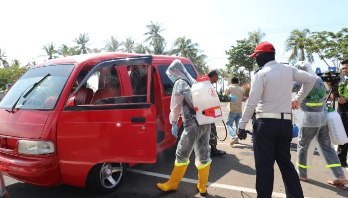 TGP Covid-19 Bantaenng menyemprotkan disinfektan pada kendaraan yang melintas di perbatasan.