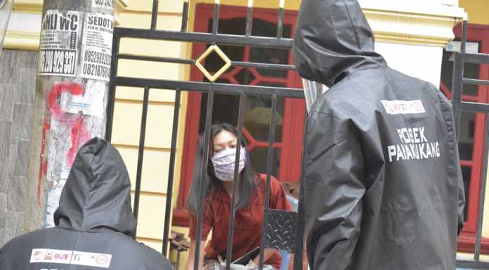 Aparat Polsek Panakkukang berpakaian APD lengkap mengambil keterangan korban pencurian dari luar pagar.(dok Polsek Panakkukang)