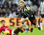 Pemain Newcastle United, Lewis Hall (hitam) terjatuh saat berebut bola dengan pemain Nottingham Forest, Morgan Gibbs-White pada Selasa 26 Desember 2023. (AFP)