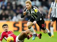 Pemain Newcastle United, Lewis Hall (hitam) terjatuh saat berebut bola dengan pemain Nottingham Forest, Morgan Gibbs-White pada Selasa 26 Desember 2023. (AFP)