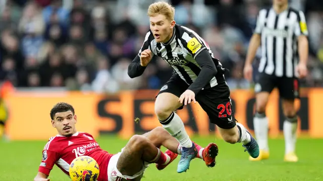 Pemain Newcastle United, Lewis Hall (hitam) terjatuh saat berebut bola dengan pemain Nottingham Forest, Morgan Gibbs-White pada Selasa 26 Desember 2023. (AFP)