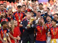 Raja Felipe VI dari Spanyol mengangkat Trofi Juara Piala Dunia FIFA bersama para punggawa La Roja. (AFP)