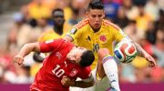 Pemain Swiss Granit Xhaka (merah) dan kapten Kolombia James Rodriguez (kuning) berebut bola di BC Place, Rabu (8/7/2026). (AFP)