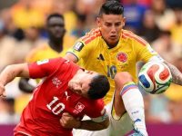 Pemain Swiss Granit Xhaka (merah) dan kapten Kolombia James Rodriguez (kuning) berebut bola di BC Place, Rabu (8/7/2026). (AFP)